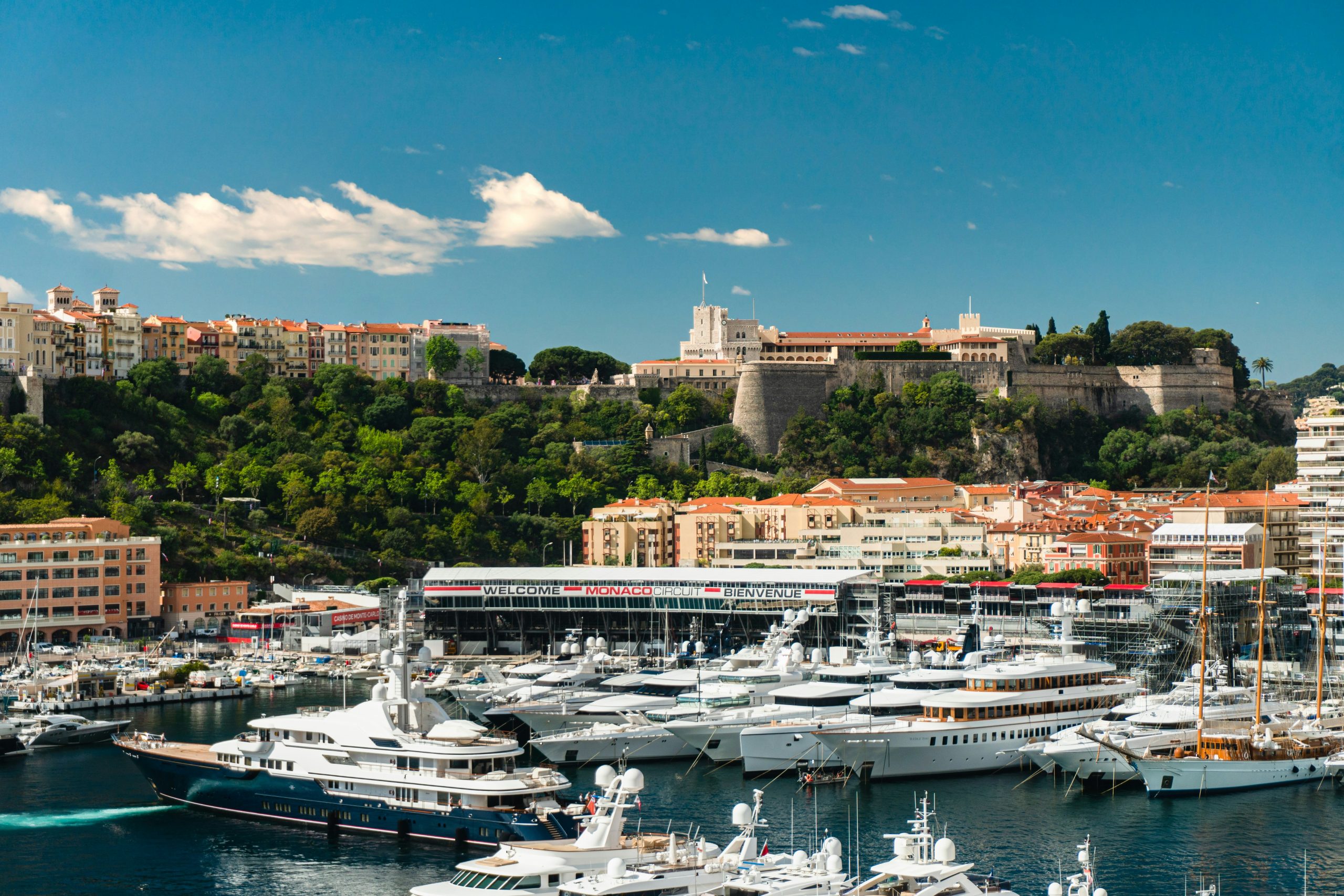 Panoramic view of Port Hercule filled with luxury yachts, with the Rock and the Prince's Palace in the background in Monaco.